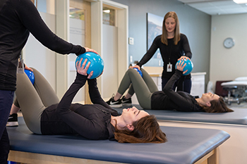 Physical therapist working with patient and medicine ball